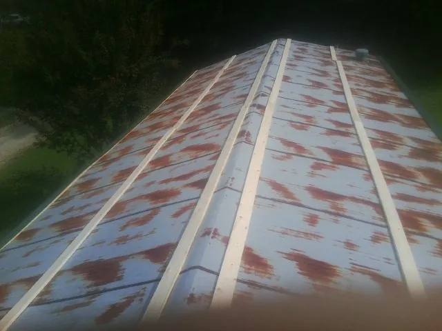 Rusted metal roof panels with new wood purlins before replacement — Storm Damage Roof Repair in Pease by Roofing Brothers
